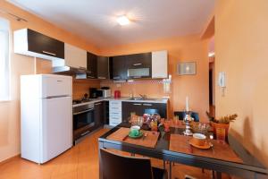 uma cozinha com uma mesa e um frigorífico branco em Apartments Karen em Vinišće
