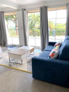 een woonkamer met een blauwe bank en een salontafel bij Maison de 2 chambres avec vue sur la mer piscine partagee et jardin clos a La Trinite a 2 km de la plage in La Trinité