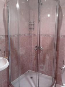 a shower with a glass door in a bathroom at Complex Balkandzhii in Apriltsi
