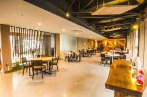 a restaurant with tables and chairs in a room at Front One Akshaya Hotel Karawang in Karawang