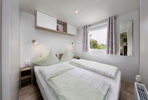 a white bed in a room with a window at KNAUS Campingpark Hennesee in Meschede +42 photos