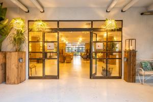 un vestíbulo abierto con puertas y muebles de cristal en Capo Peloro Hotel, en Torre Faro