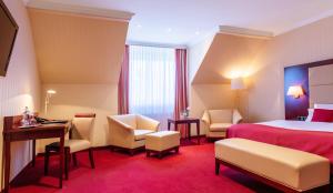 a hotel room with a bed and a desk and chairs at Hotel Amaris Bremerhaven in Bremerhaven