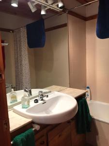 a bathroom with a white sink and a tub at Apartamentos Tanau in Baqueira-Beret