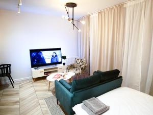 Televízia a/alebo spoločenská miestnosť v ubytovaní ONE Apartamenty Gąsiorowskich 4