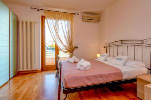 a bedroom with a bed with white pillows and a window at My Peschiera Family Home XL in Peschiera del Garda