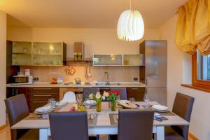 una cucina con tavolo e sedie e una sala da pranzo di My Peschiera Family Home XL a Peschiera del Garda
