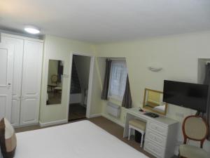 una camera con letto, scrivania e TV di Beau Rivage a St Brelade Altre 25 foto