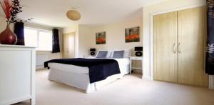 a bedroom with a bed with a black and white blanket at Osprey in Bracknell