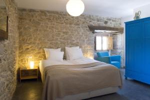 - une chambre avec un grand lit et un mur en pierre dans l'établissement Hotel Rural Casa La Sonrisa, à Hedeso