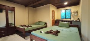 a bedroom with two beds and a sink and a window at Papa Pippo Otres Village in Sihanoukville