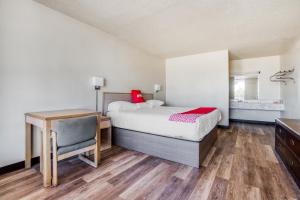 a bedroom with a bed and a desk and a table at OYO Hotel Waco University Area I-35 in Waco