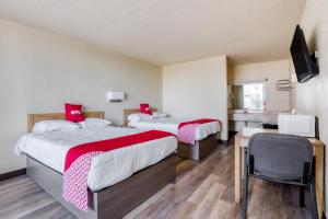 Habitación con 2 camas con almohadas rojas. en OYO Hotel Waco University Area I-35, en Waco