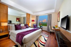 a hotel room with a large bed and a television at The Place Gurugram, a member of Radisson Individuals in Gurgaon