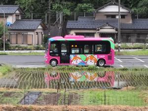a pink bus is parked in a parking lot at 田舎生活体験福井県観光者向け古民家 in Sabae