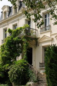 an ivy covered building with stairs and a balcony at Manoir de Collonges au mont d'or in Collonges-au-Mont-dʼOr
