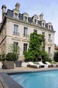 a large building with a swimming pool in front of it at Manoir de Collonges au mont d'or in Collonges-au-Mont-dʼOr