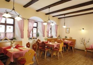 ein Restaurant mit Tischen, Stühlen und Fenstern in der Unterkunft Pension zur Kurfürstin in Wolkenstein