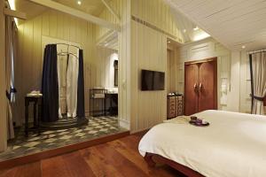 a bedroom with a large bed and a bathroom at Burasari Heritage Luang Prabang in Luang Prabang
