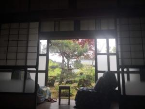 a room with a window looking out at a tree at 田舎生活体験福井県観光者向け古民家 in Sabae