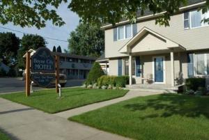 a house with a sign in front of a house at Boyne City Motel in Boyne City