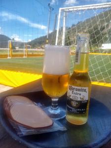 a bottle of beer and a glass on a table at Posadas San Antonio Campestre in Tibasosa