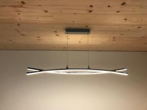 aendant light hanging from a wooden ceiling at Murmenta Appartements in Vandans