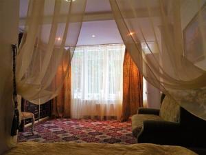 a bedroom with a bed and a window with curtains at Royal Nikita Apartments in Nikita