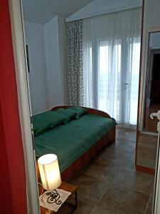 a bedroom with a green bed and a window at Apartments Jovanic with 2 bedrooms in Sutomore