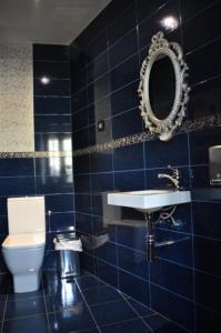 baño de azulejos azules con lavabo y aseo en El Rincón Del Convento en Oña