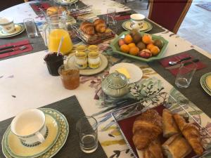einen Tisch mit einem Frühstück mit Croissants und Orangen in der Unterkunft Le Clos du Pont Martin in Saint-Briac-sur-Mer
