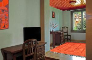 ein Wohnzimmer mit einem Schreibtisch und einem TV in der Unterkunft Hotel Garona in Salardú