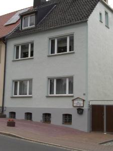 ein weißes Haus mit Fenstern auf einer Straße in der Unterkunft Ferienwohnung Böhnstedt in Thale