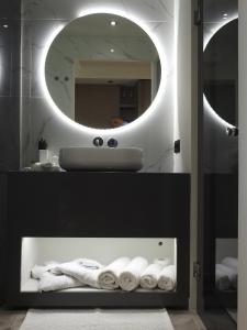 ein Badezimmer mit einem Waschbecken, einem Spiegel und Handtüchern in der Unterkunft Nikos Ikies in Theologos