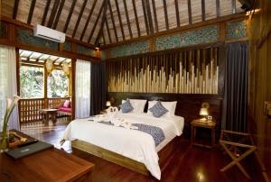 1 dormitorio con 1 cama en una habitación en Parvati Retreat Villas, en Ubud