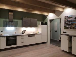 una cocina con armarios blancos y un aparato negro en Ferienhaus Hofmeyer en Hofgeismar
