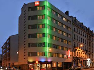 un bâtiment dont le côté est baigné de lumière verte dans l'établissement ibis Lyon Centre, à Lyon