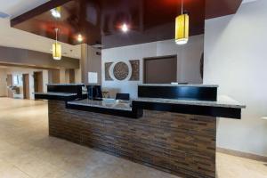 a lobby with a bar with a brick wall at Ramada by Wyndham Glendale Heights/Lombard in Glendale Heights