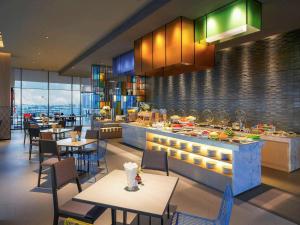 a restaurant with tables and chairs and a buffet at ibis Styles Bangkok Sukhumvit Phra Khanong in Bangkok