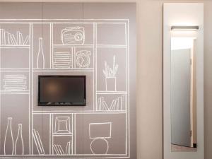 a wall mural with a tv and drawings on it at ibis Lyon Centre in Lyon