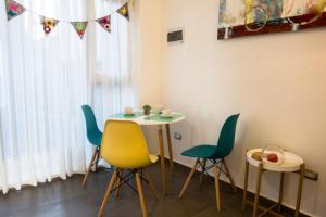 mesa y sillas en una habitación con ventana en Loftbellavistavalparaiso, en Valparaíso