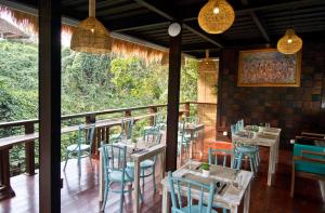 un restaurante con mesas y sillas en un balcón en Parvati Retreat Villas en Ubud