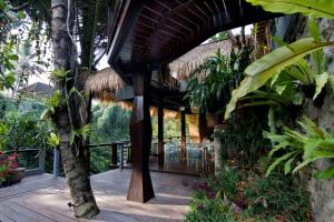 un edificio con un porche con árboles y plantas en Parvati Retreat Villas, en Ubud