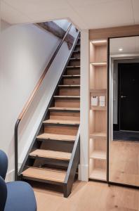 a staircase in a living room with wooden shelves at Copenhagen Admiral Hotel in Copenhagen