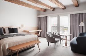 a bedroom with a bed and chairs and a table at Copenhagen Admiral Hotel in Copenhagen +37 photos