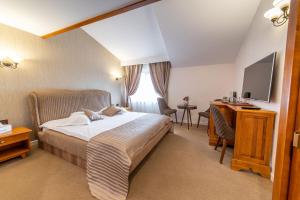 ein Hotelzimmer mit einem Bett, einem Schreibtisch und einem TV in der Unterkunft RED CONFORT HOTEL Boutique in Alexandria