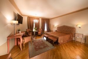 a bedroom with a bed and a desk and a table at San Luca Palace in Lucca