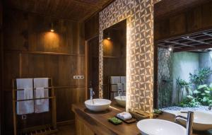 a bathroom with two sinks and a large mirror at Benisari Batik Garden Cottage in Ubud +35 photos