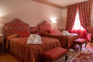 a hotel room with two beds with red covers at San Luca Palace in Lucca