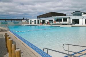 a large swimming pool with blue water in front of a building at KNAUS Campingpark Dorum in Dorum Neufeld